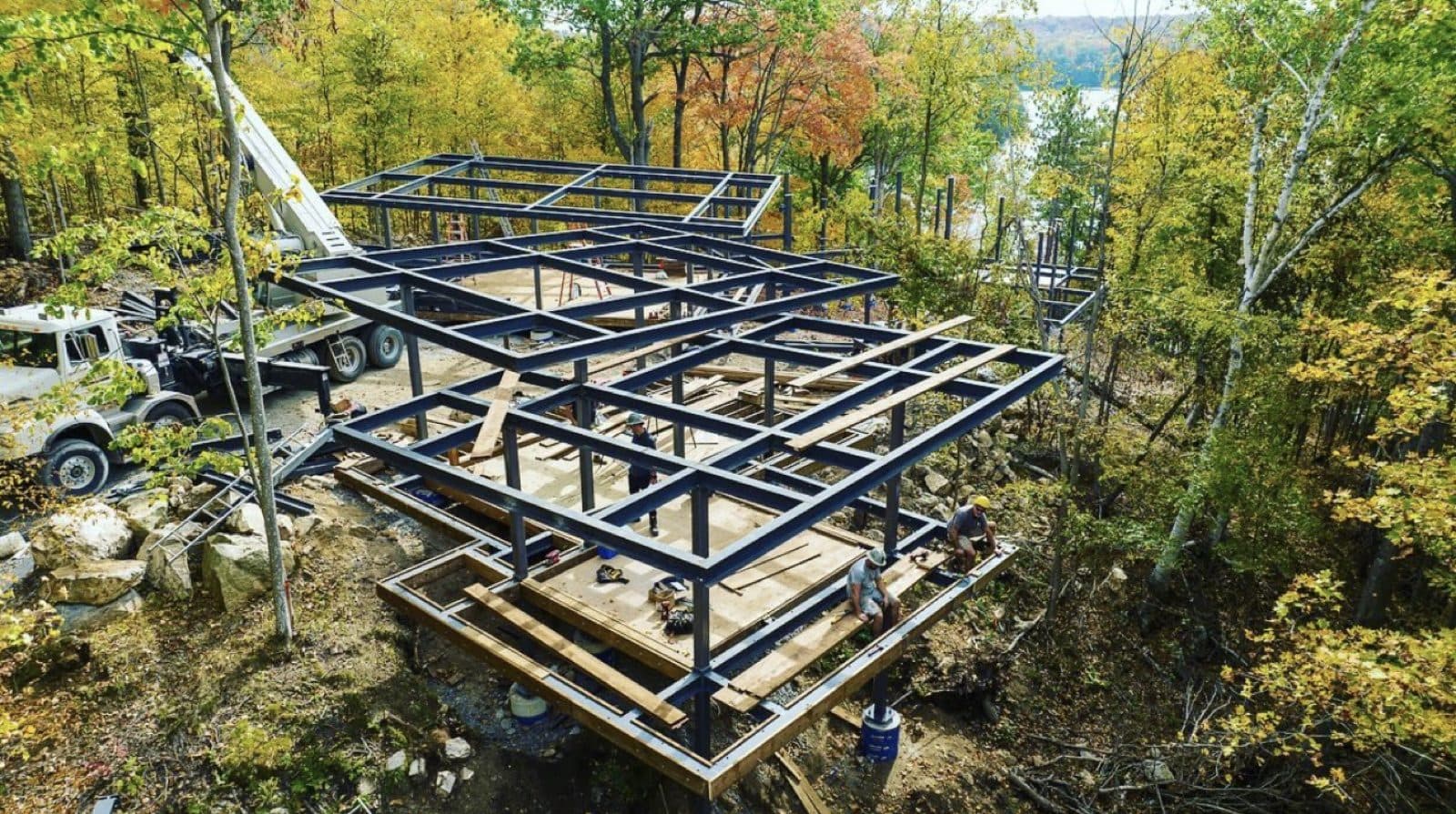 SiloTech crew installing a structural steel frame with crane support on a wooded lakeside site