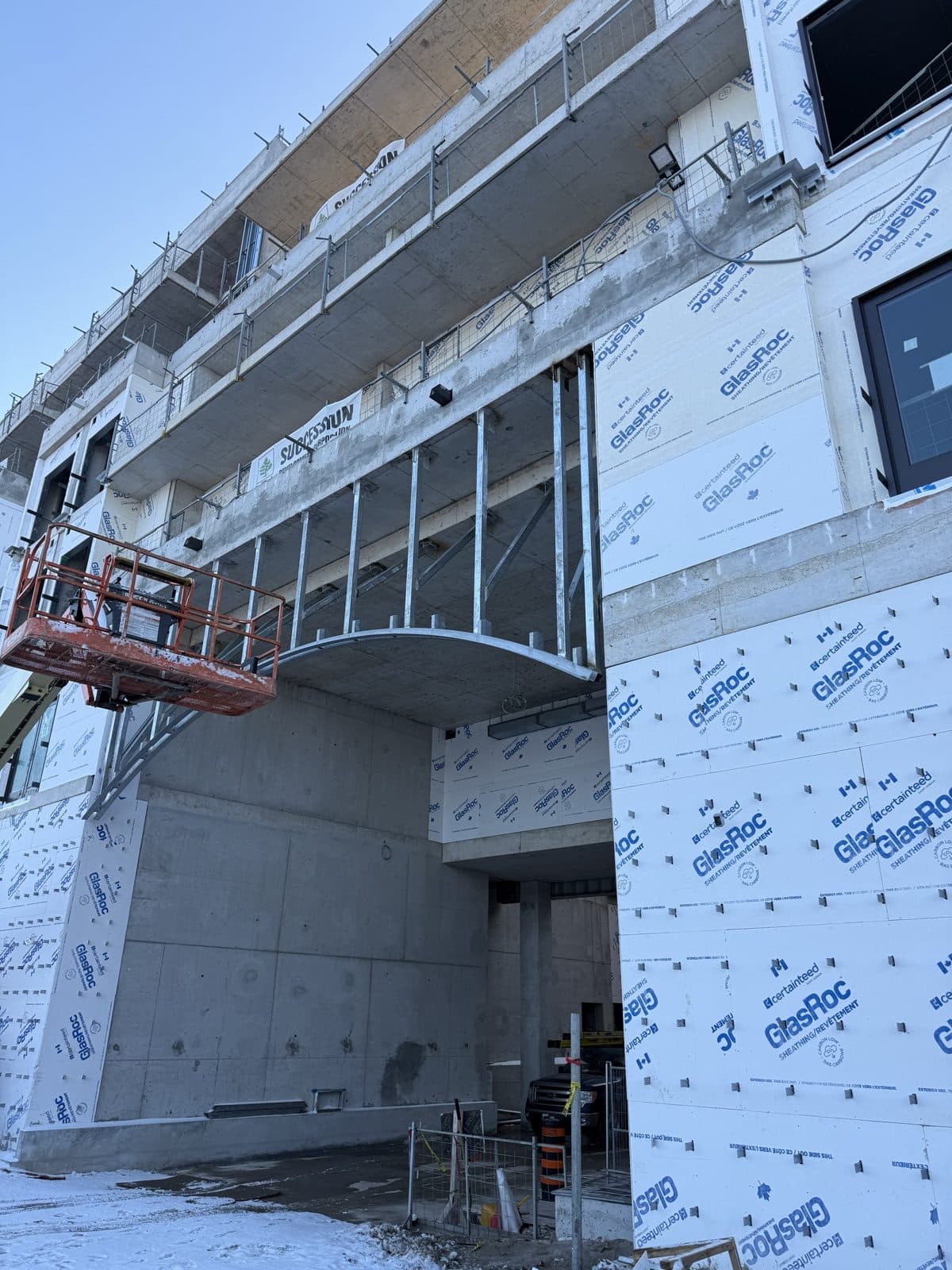 Curved canopy steel installed on an occupied commercial building from a boom lift