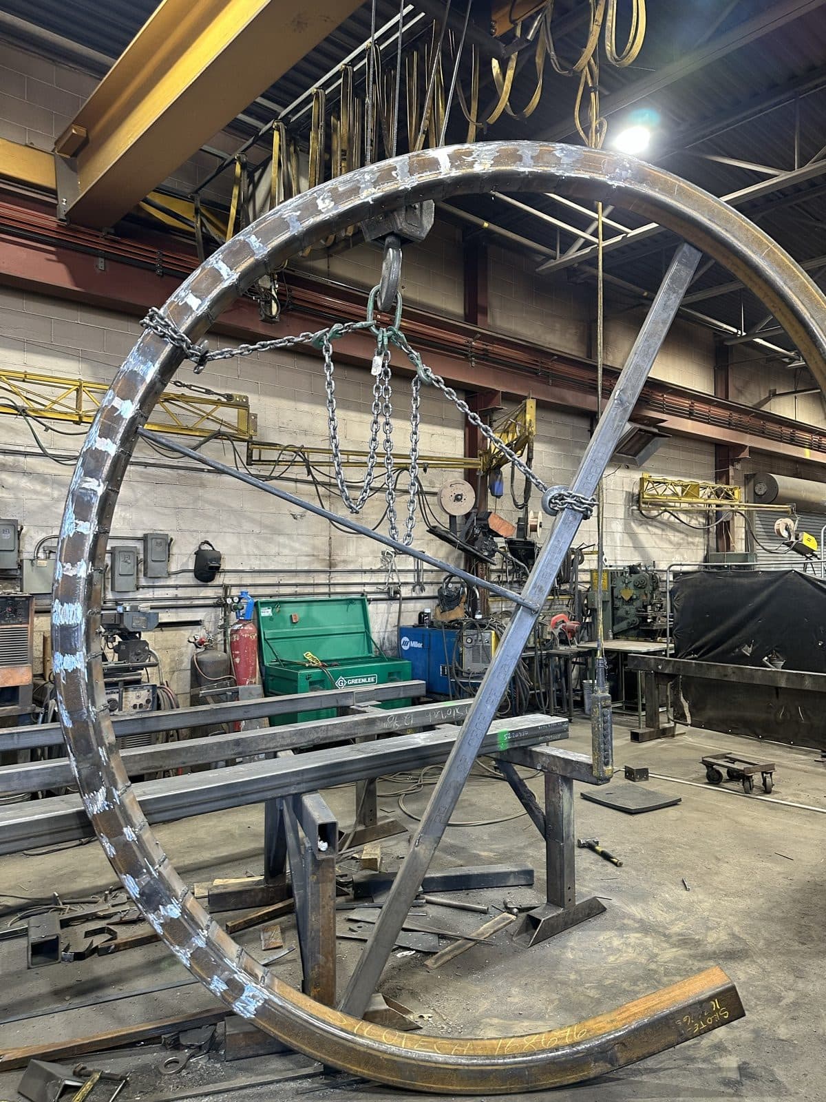 Large custom-rolled steel ring rigged to the overhead crane inside the SiloTech shop